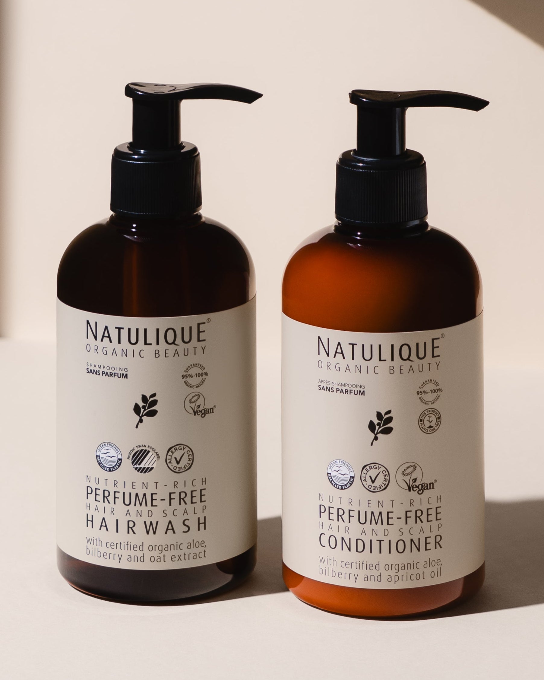 Two bottles of Natulique hair care products on a light background